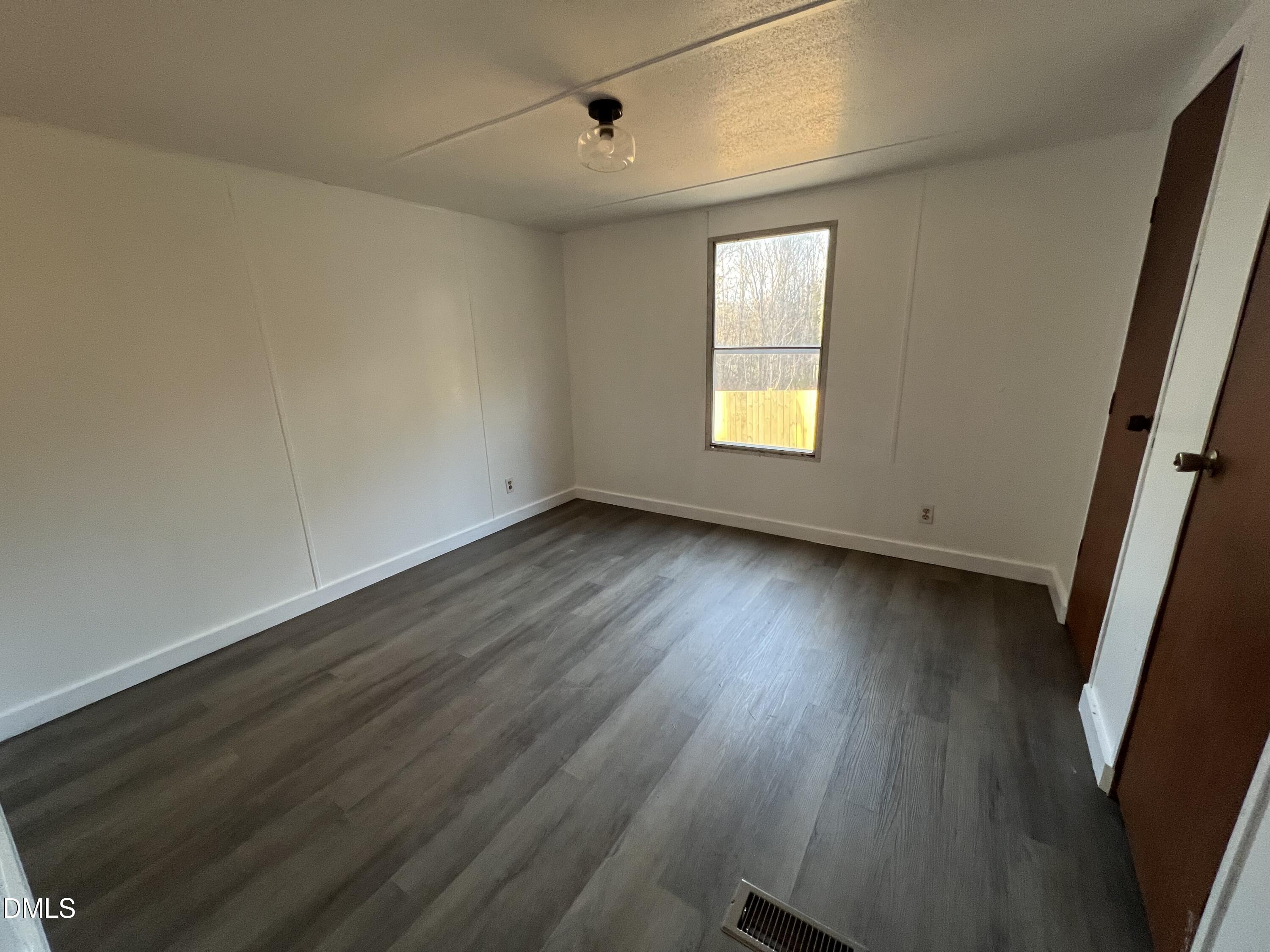 1071 Davis Bugg Road Warrenton, NC 27589 - Photo 11 of 13 a view of an empty room with wooden floor and a window