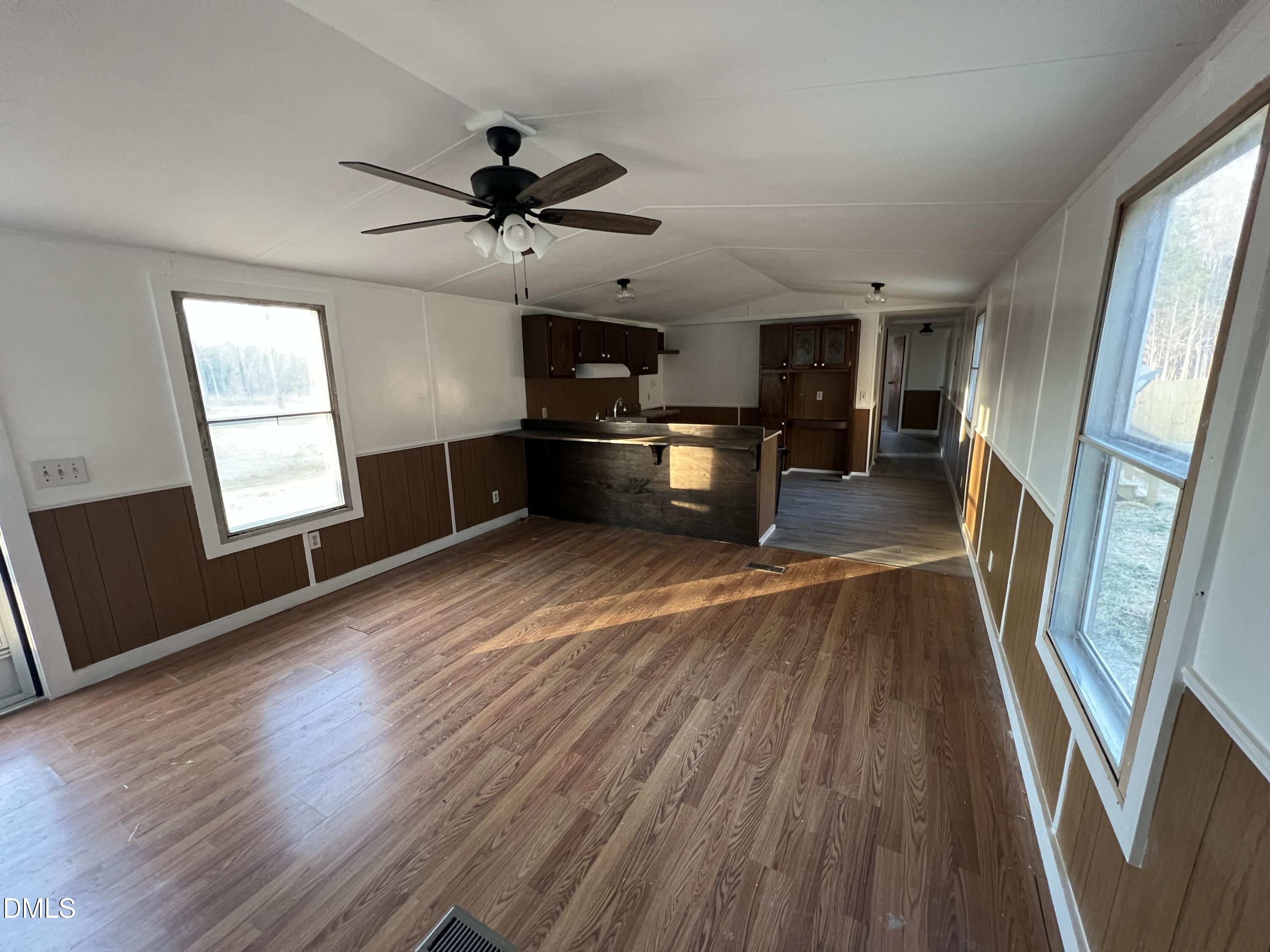 1071 Davis Bugg Road Warrenton, NC 27589 - Photo 7 of 13 an empty room with wooden floor fan and windows