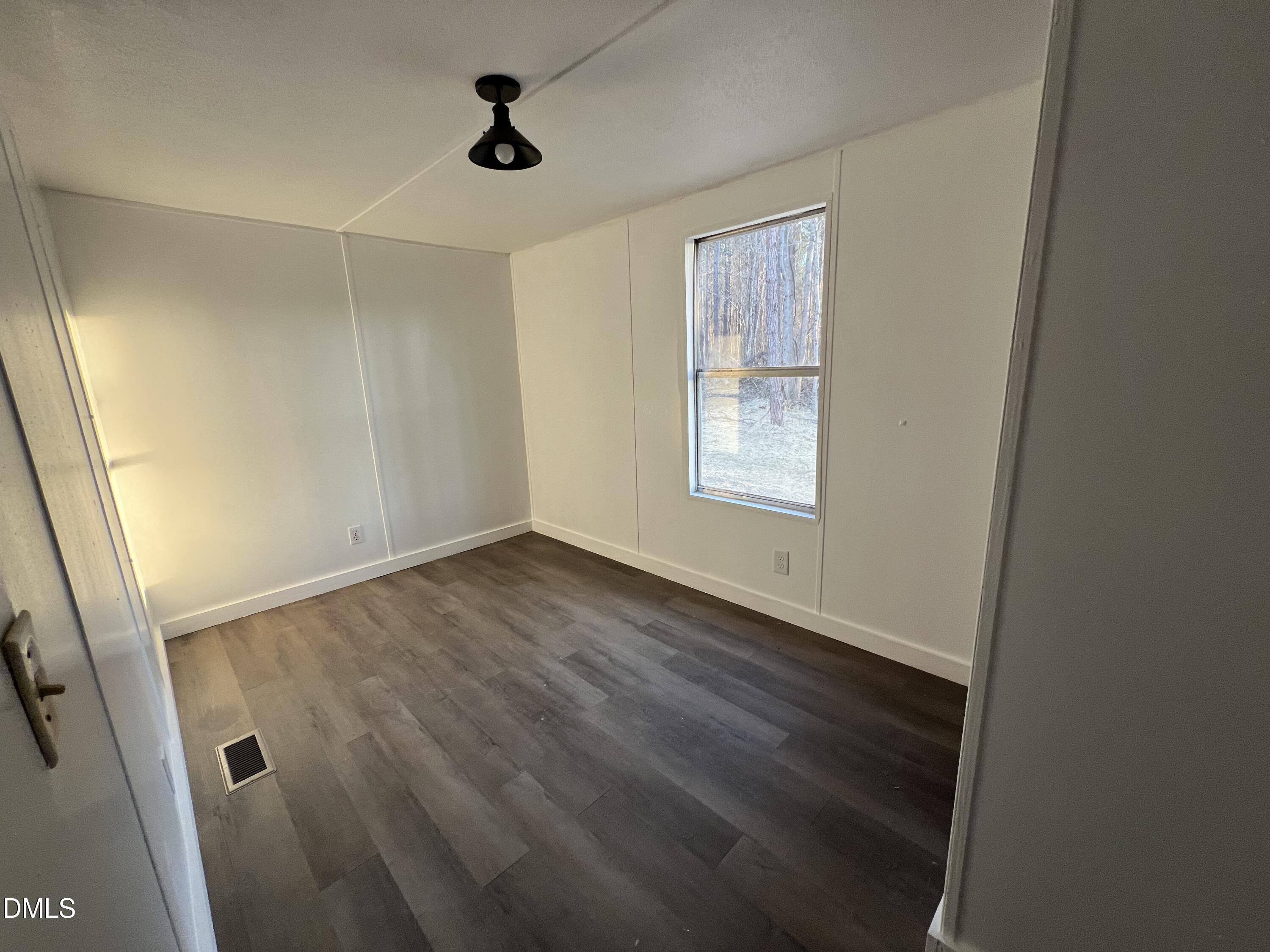 1071 Davis Bugg Road Warrenton, NC 27589 - Photo 9 of 13 an empty room with wooden floor and windows