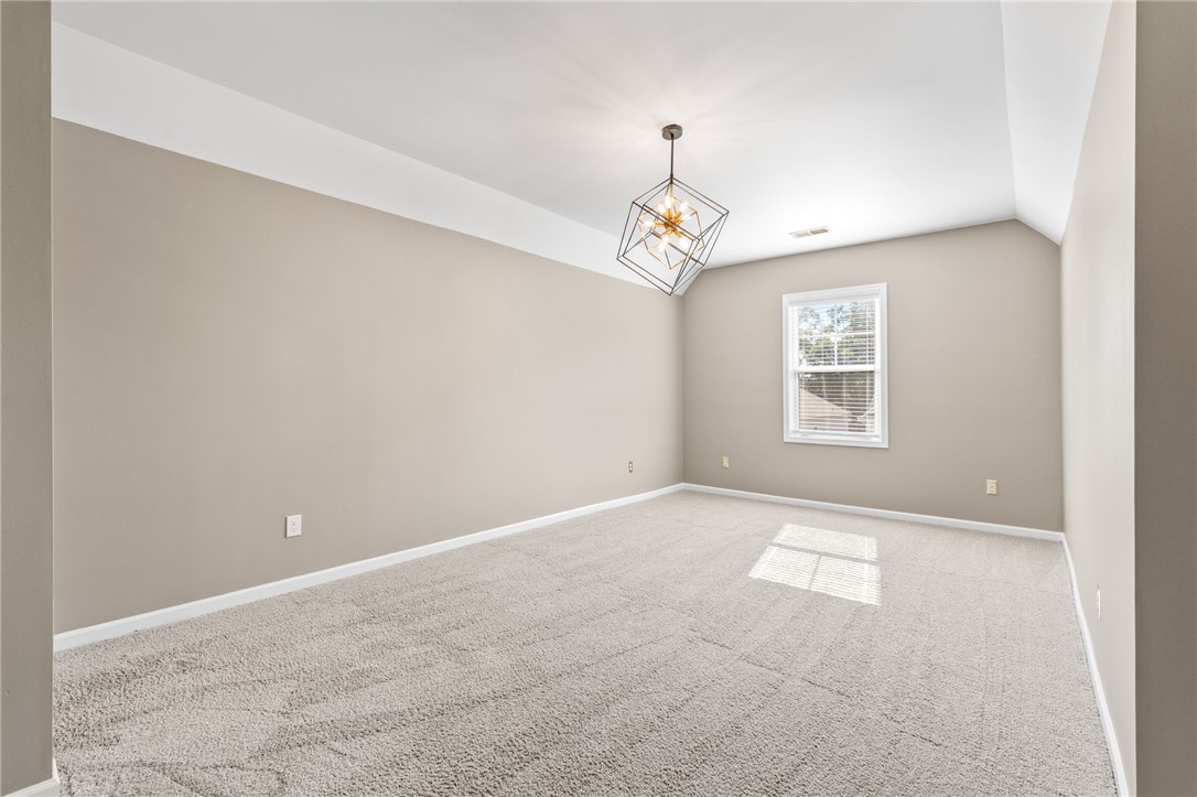 127 Spyglass Lane Pendleton, SC 29670 - Photo 32 of 45 Soft carpeting pairs with a tray ceiling and contemporary light fixture in this bedroom.