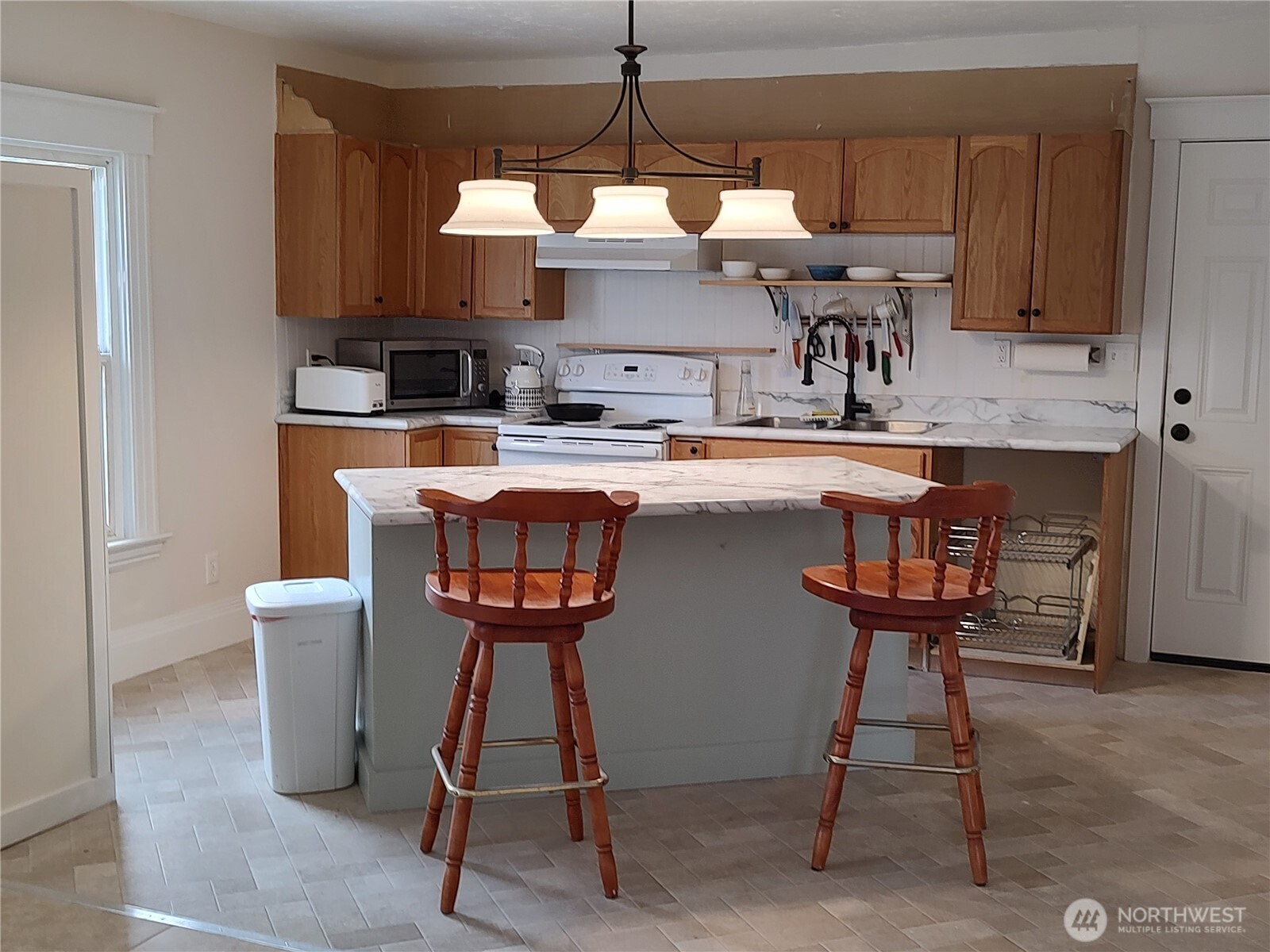 316 North F Street Aberdeen, WA 98520 - Photo 18 of 40 a kitchen with stainless steel appliances a table and chairs in it