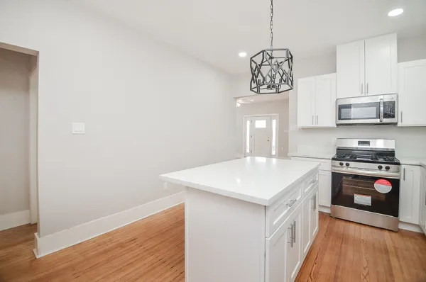 a kitchen with stainless steel appliances granite countertop a stove a sink and a microwave