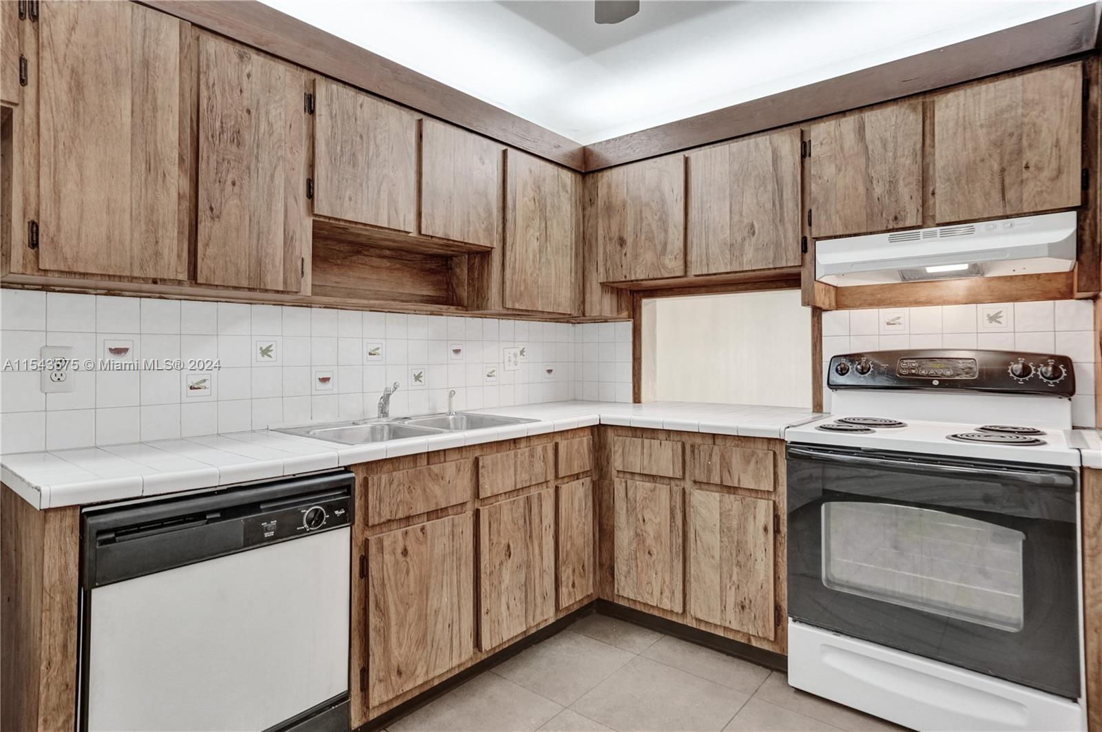 a kitchen with granite countertop wood cabinets stainless steel appliances and sink