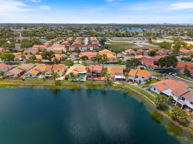 an aerial view of residential houses with outdoor space and lake view