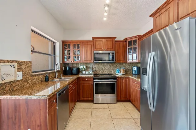 a kitchen with stainless steel appliances granite countertop a refrigerator stove and sink