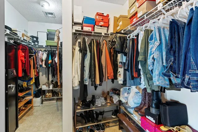 a view of walk in closet with clothes and shoes