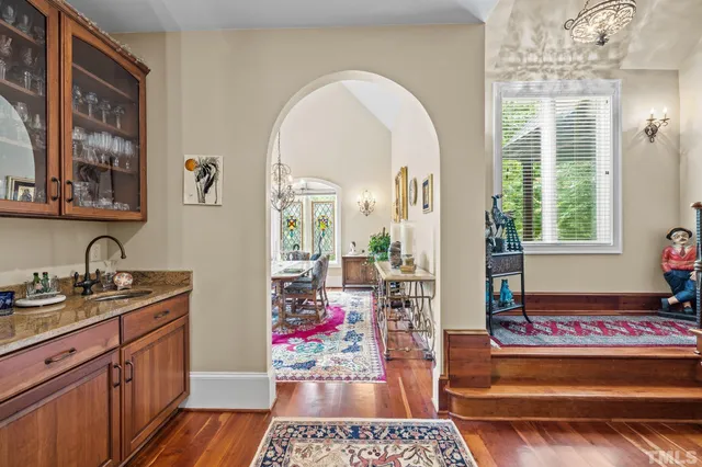 a living room with furniture a fireplace and a chandelier