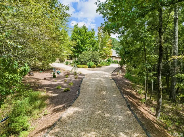 a front view of a house with a yard and potted plants