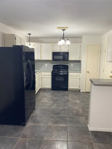 a kitchen with a refrigerator and a stove