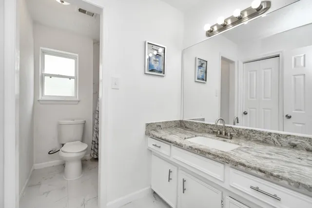 a bathroom with a granite countertop sink and a mirror