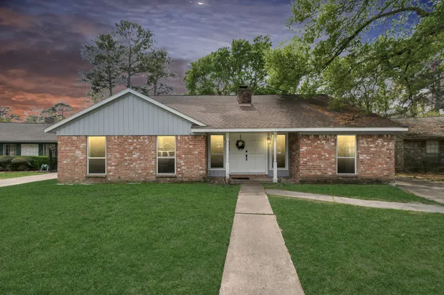 a front view of a house with a yard and trees