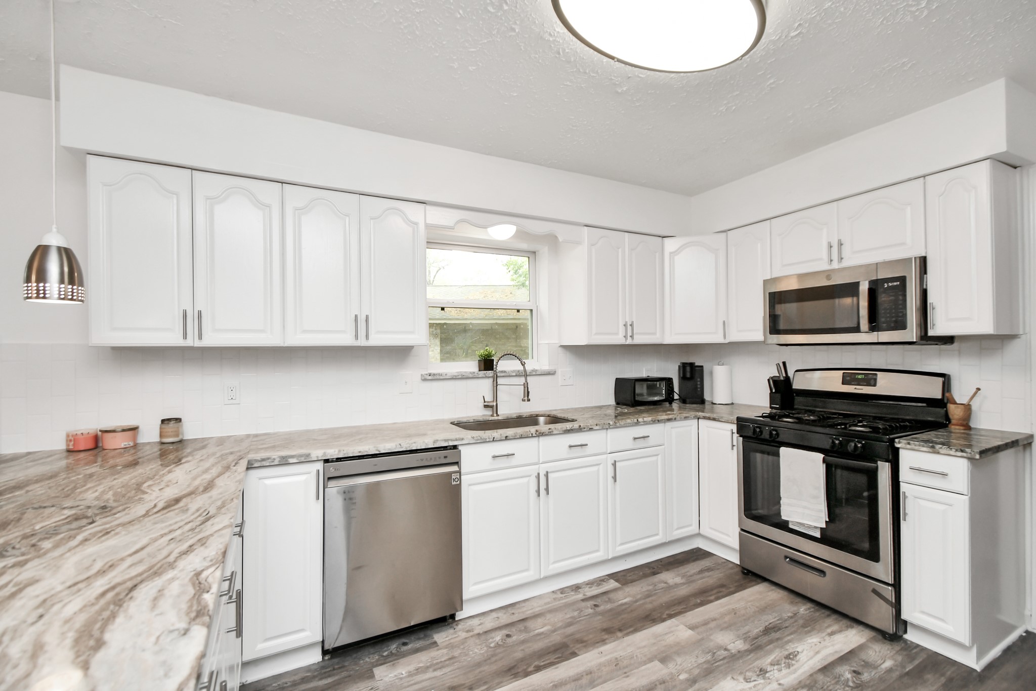 22723 Earlmist Drive Spring, TX 77373 - Photo 6 of 20 a kitchen with white cabinets stainless steel appliances and sink
