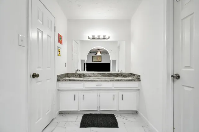 a view of granite countertop white cabinets and a wooden floor