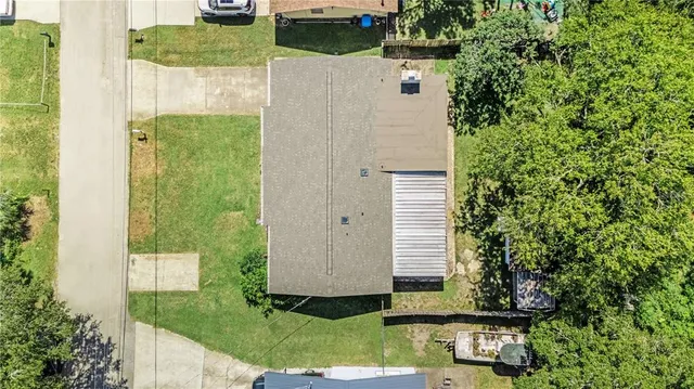 a aerial view of a house with a yard and large tree