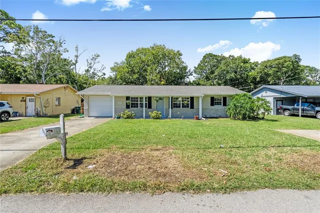 a front view of house with a yard and potted plants