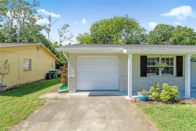 a front view of a house with a yard and potted plants
