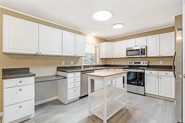 a kitchen with granite countertop white cabinets and appliances