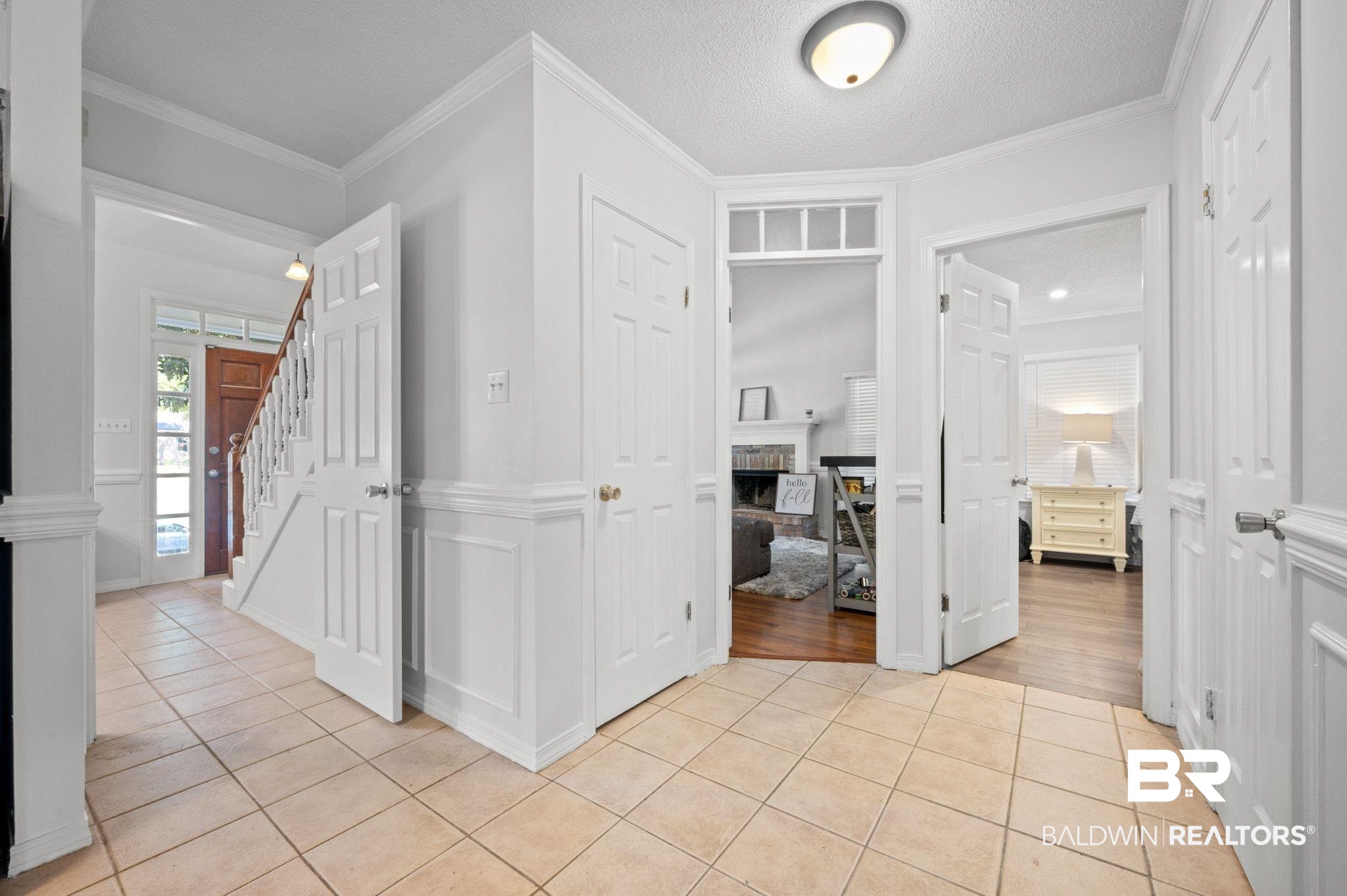 6705 Autumn Ridge Drive Mobile, AL 36695 - Photo 12 of 24 Hallway featuring a textured ceiling, ornamental molding, and light tile patterned flooring