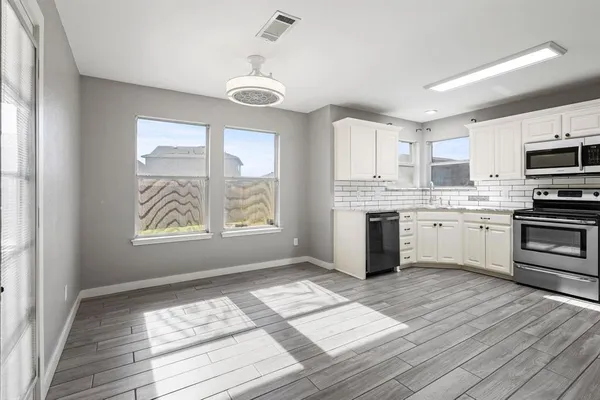 a kitchen with kitchen island granite countertop a stove a sink and a microwave