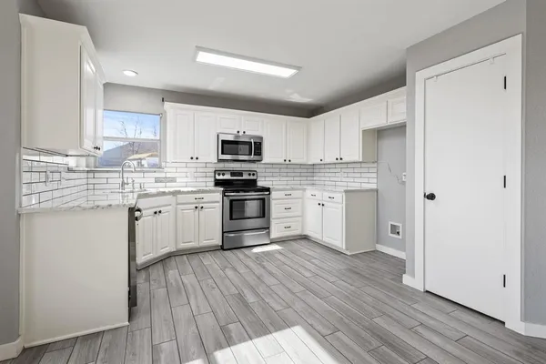 a kitchen with white cabinets stainless steel appliances and sink