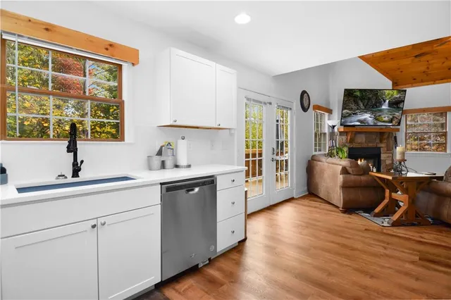 a kitchen with stainless steel appliances a sink cabinets and wooden floor
