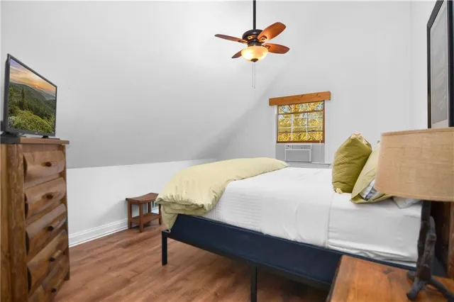 a bedroom with a bed and a flat tv screen on dresser