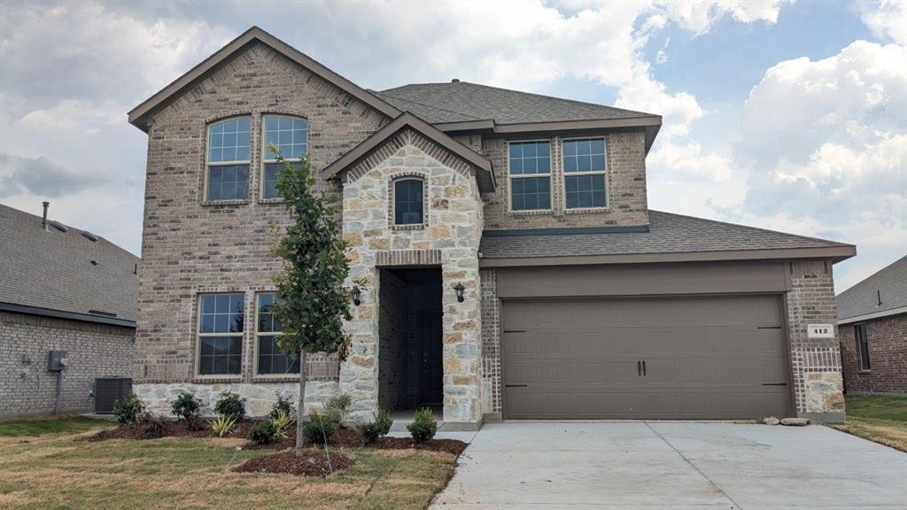 412 Carthage Street Caddo Mills, TX 75135 - Photo 1 of 32 Two-story residence featuring a brick and stone facade, a two-car garage, and a concrete driveway