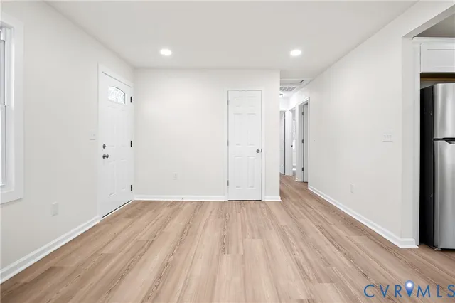 a view of an empty room with wooden floor