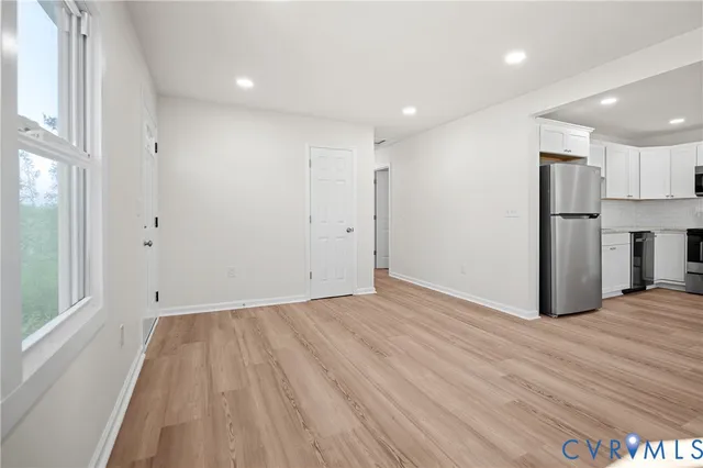 a view of empty room with wooden floor and window