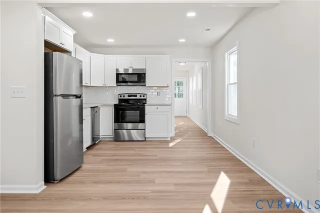 a kitchen with stainless steel appliances a refrigerator and a stove top oven