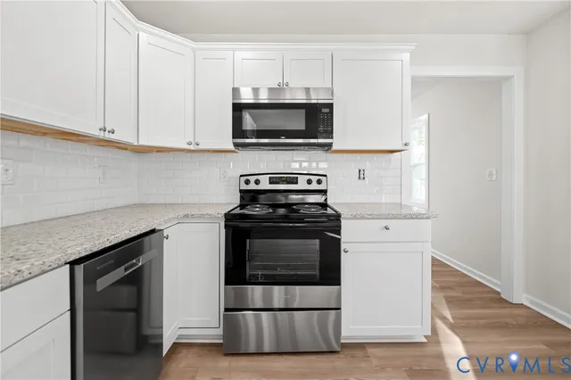 a kitchen with granite countertop a stove and a microwave