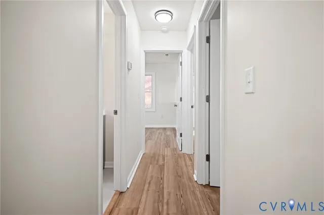a view of a hallway with wooden floor and staircase