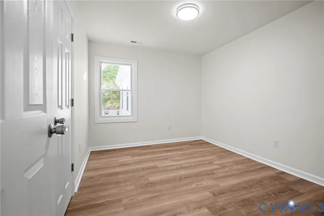 wooden floor in an empty room with a window