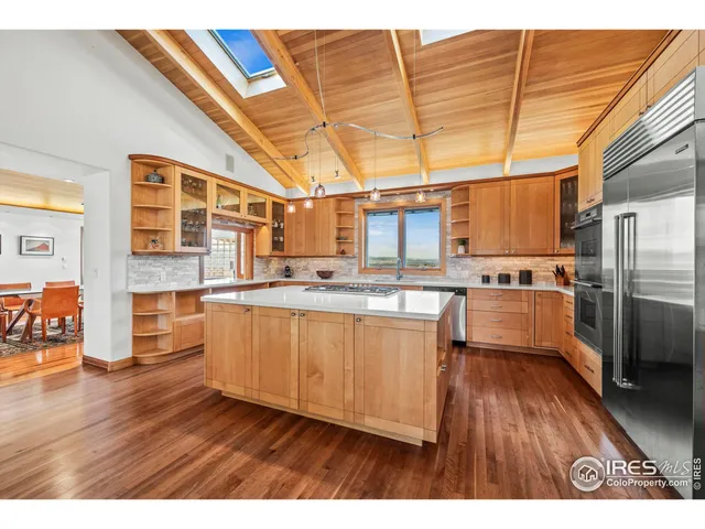 a kitchen with stainless steel appliances a refrigerator and wooden floor