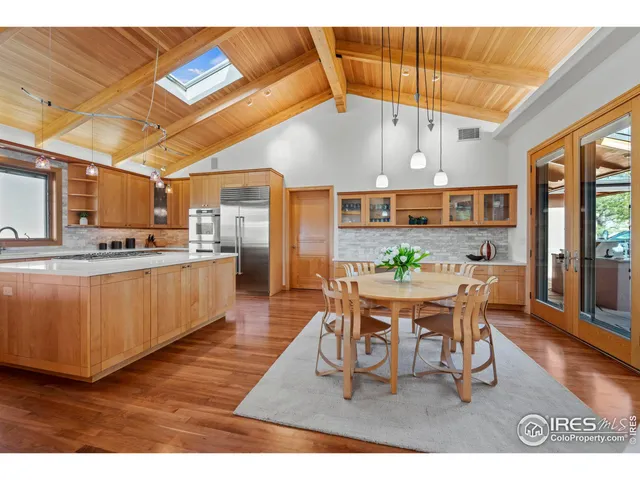 a dining room with stainless steel appliances kitchen island granite countertop a table chairs and a view of living room