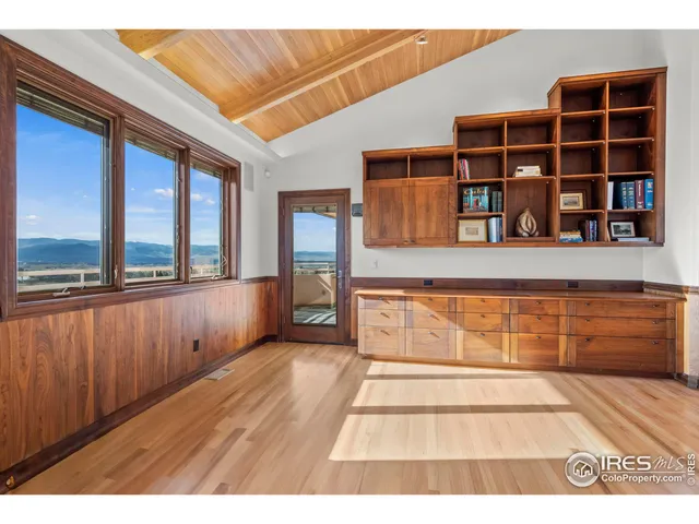 a view of an entryway with wooden floor and cabinet