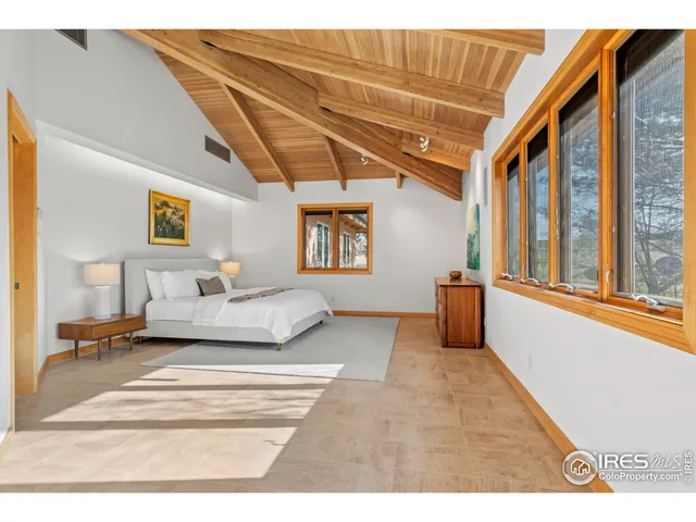 a spacious bedroom with a large bed and a chandelier