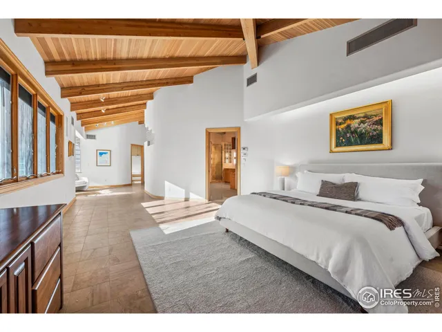 a bedroom with a bed and a painting on the wall