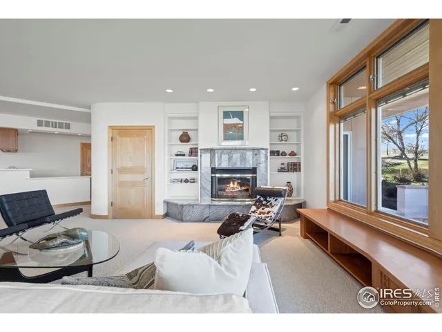 a living room with furniture a fireplace and a large window