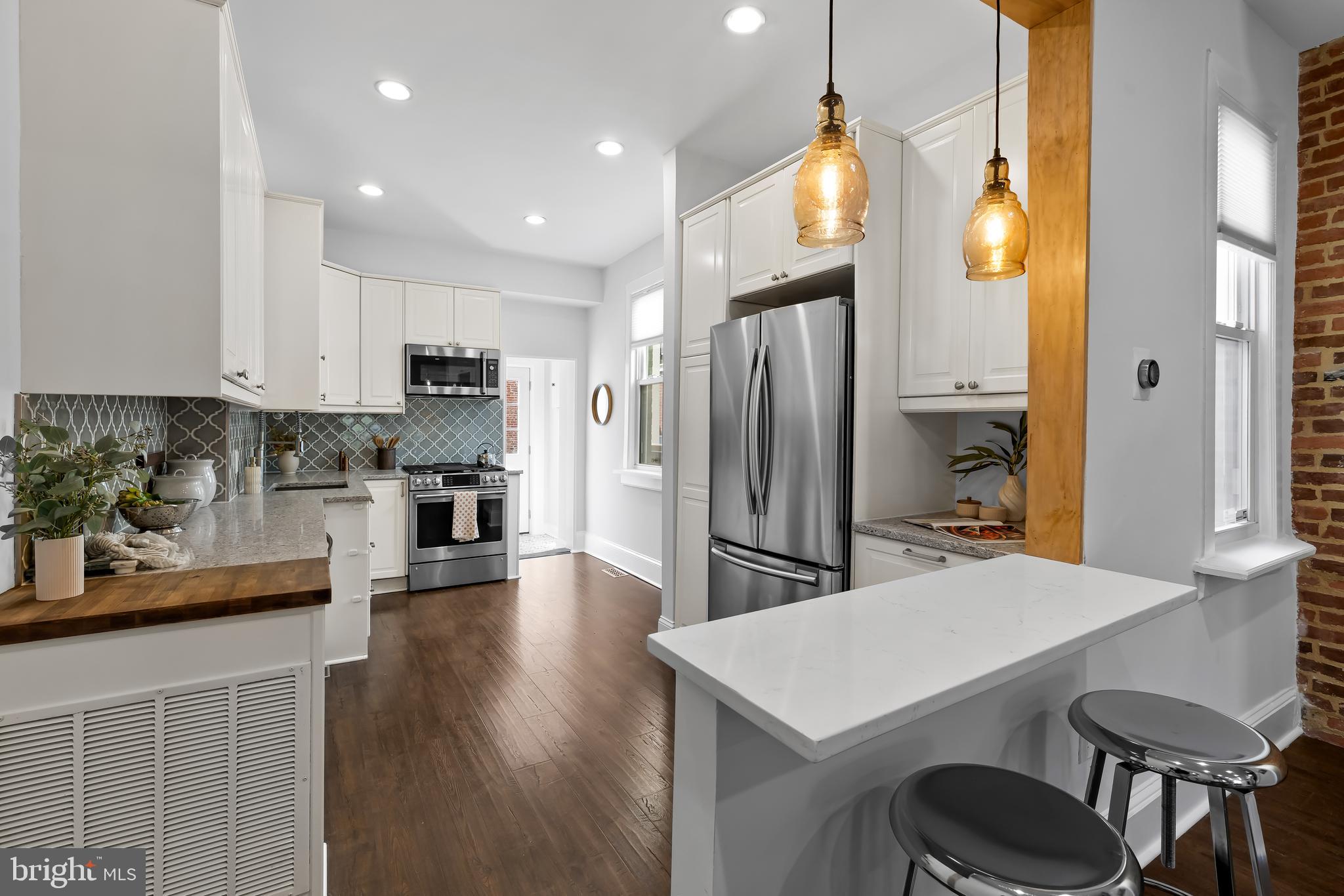 2529 Eastern Avenue Baltimore, MD 21224 - Photo 13 of 50 a kitchen with refrigerator cabinets dining table and chairs