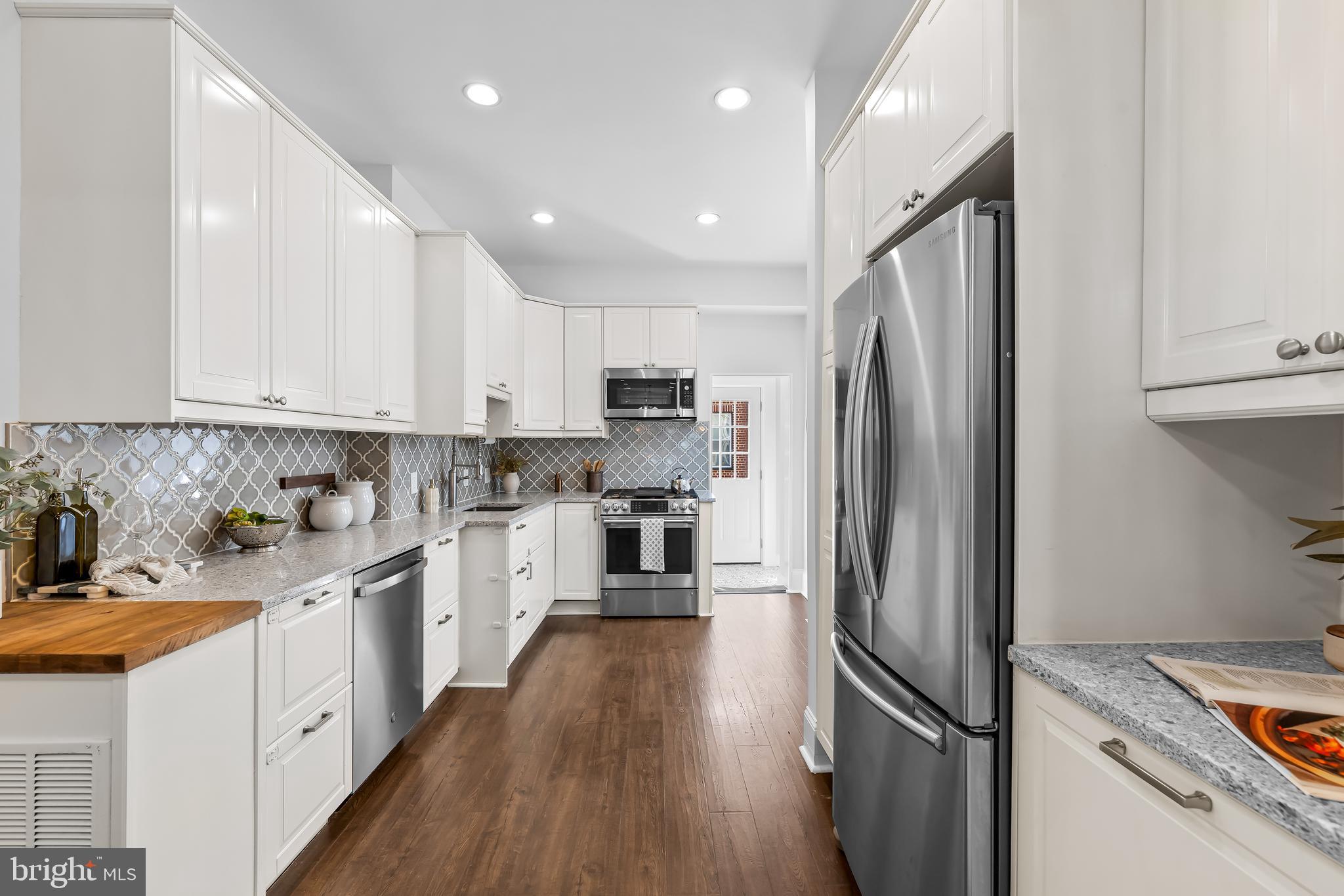 2529 Eastern Avenue Baltimore, MD 21224 - Photo 14 of 50 a kitchen with white cabinets and stainless steel appliances