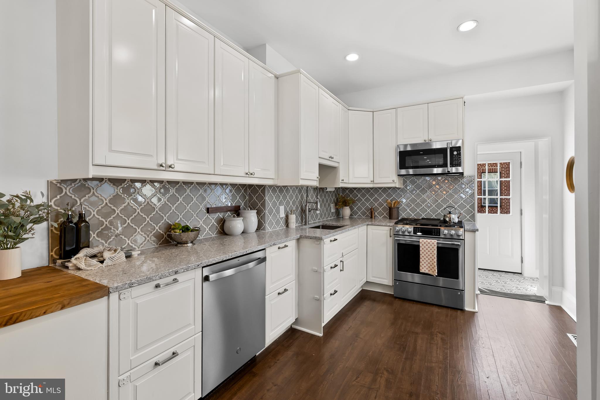 2529 Eastern Avenue Baltimore, MD 21224 - Photo 15 of 50 a kitchen with stainless steel appliances granite countertop a stove a sink and white cabinets