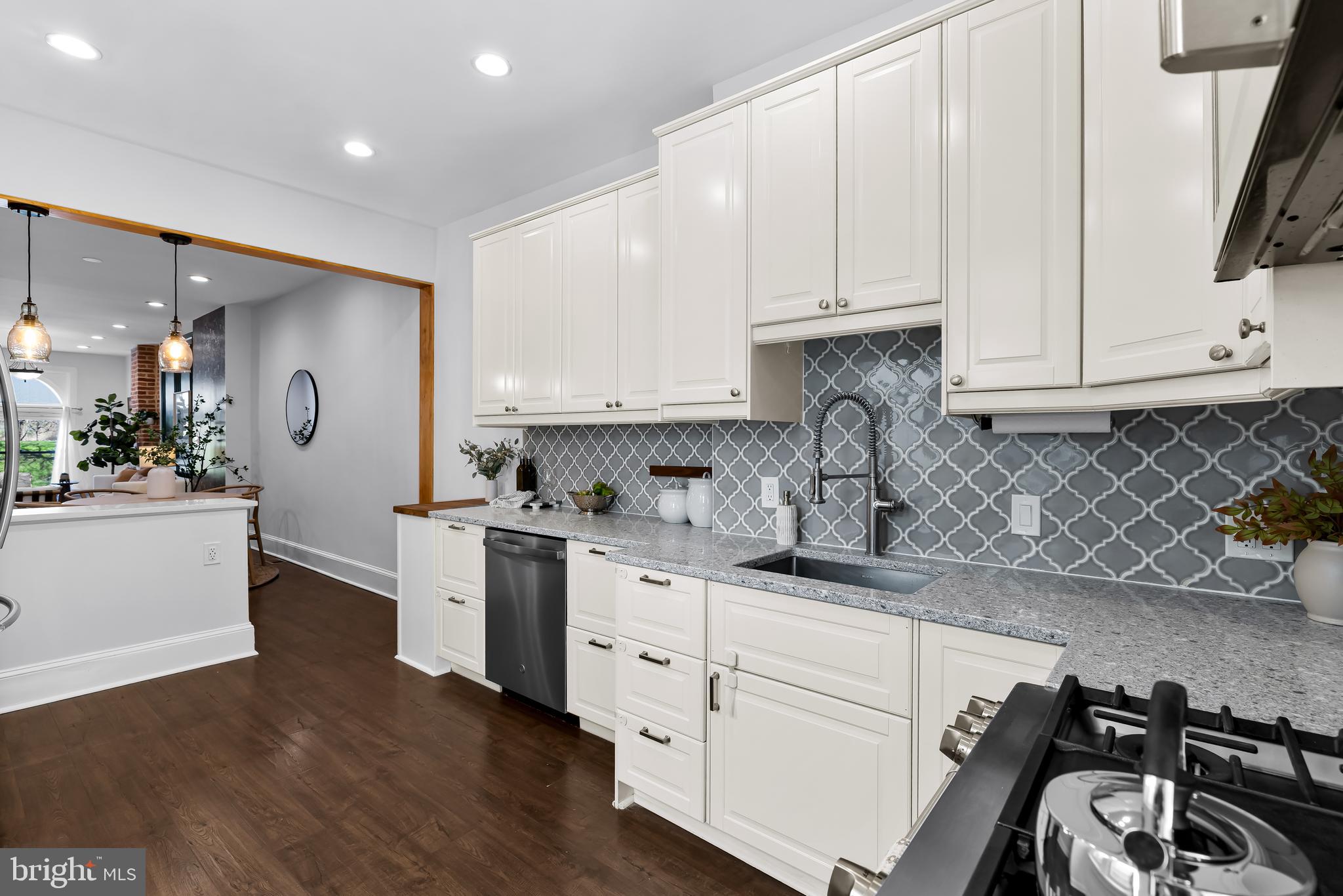2529 Eastern Avenue Baltimore, MD 21224 - Photo 16 of 50 a kitchen with granite countertop white cabinets and white appliances