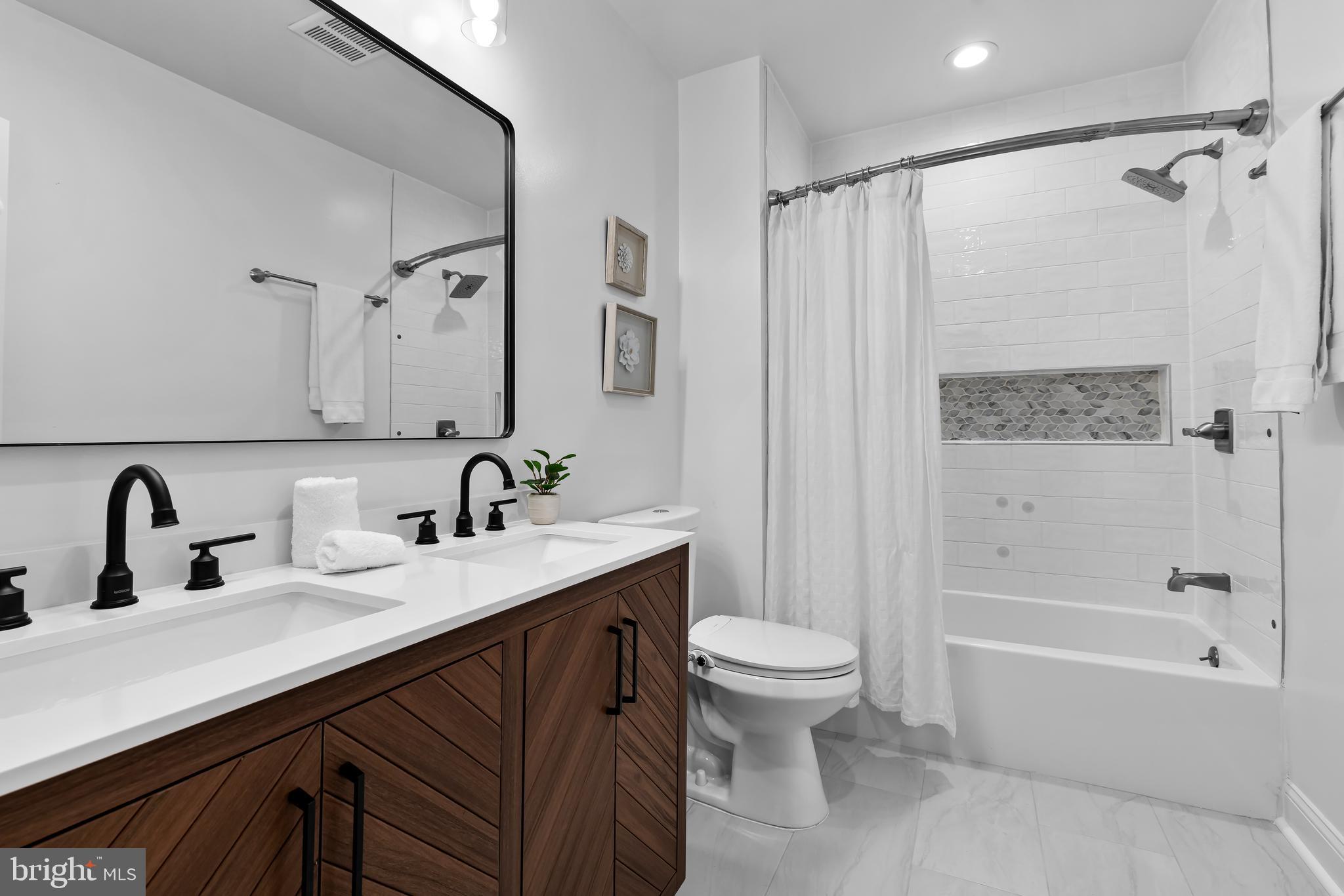 2529 Eastern Avenue Baltimore, MD 21224 - Photo 25 of 50 a bathroom with a double vanity sink toilet mirror and shower