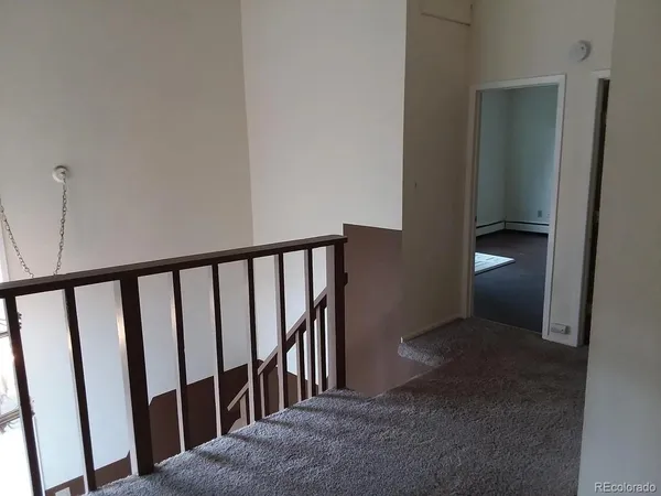 an empty room with wooden floor & windows