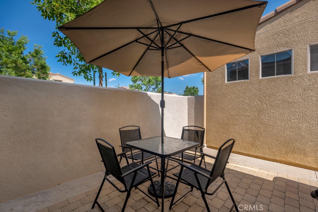 11522 Cararra Lane Porter Ranch, CA 91326 - Photo 23 of 32 a patio table and chairs under an umbrella