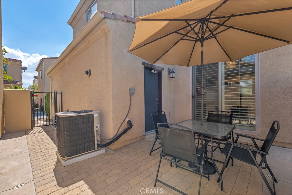11522 Cararra Lane Porter Ranch, CA 91326 - Photo 24 of 32 a patio with a table and chairs under an umbrella