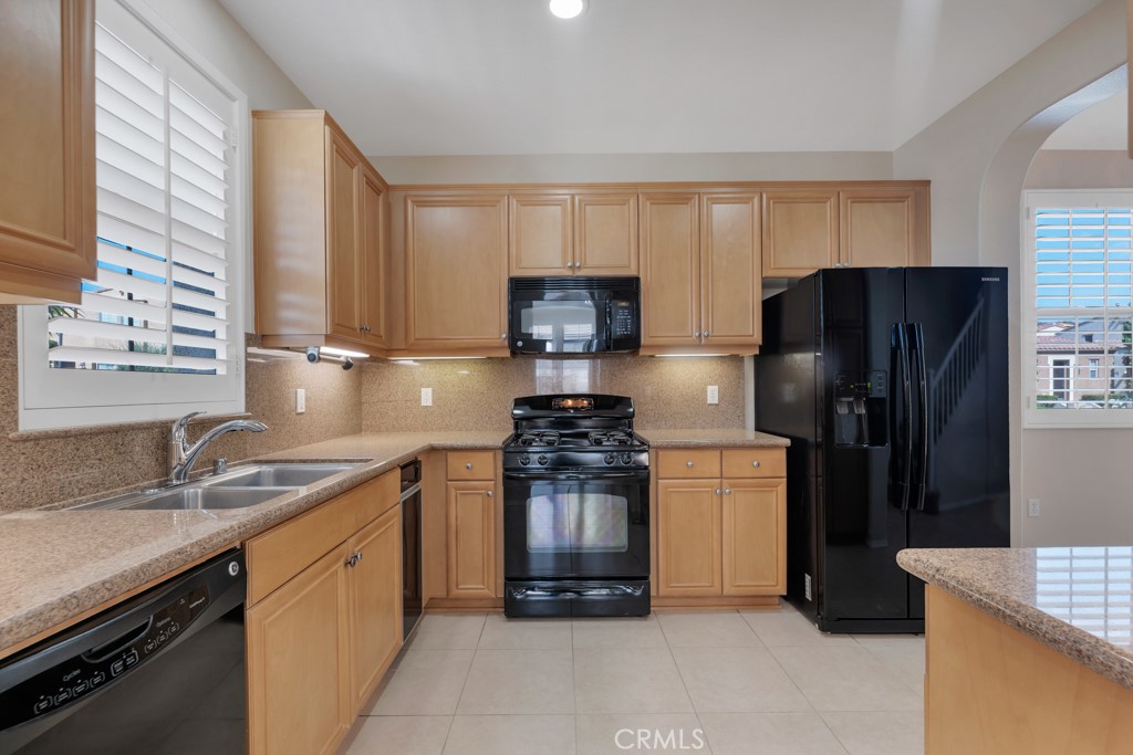 11522 Cararra Lane Porter Ranch, CA 91326 - Photo 7 of 32 a kitchen with a refrigerator and a sink