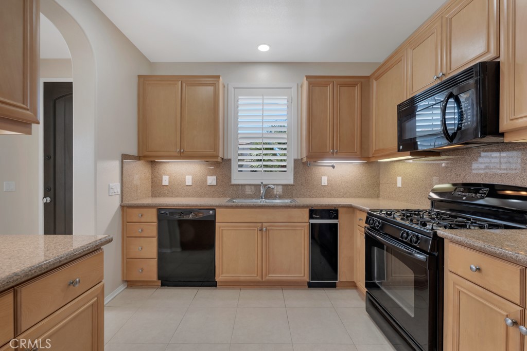 11522 Cararra Lane Porter Ranch, CA 91326 - Photo 8 of 32 a kitchen with granite countertop a stove sink and cabinets