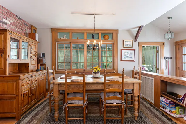 a view of a dining room with furniture a chandelier and wooden floor